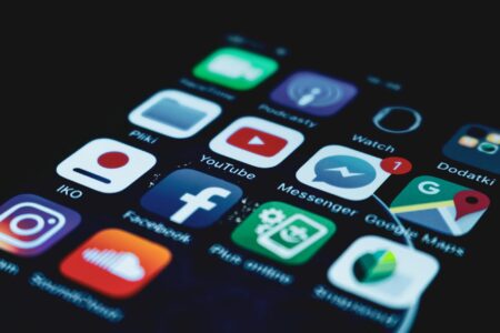 Apple and Google Face New Antitrust Investigations Over App Store Policies Close-up view of smartphone screen displaying various mobile application icons