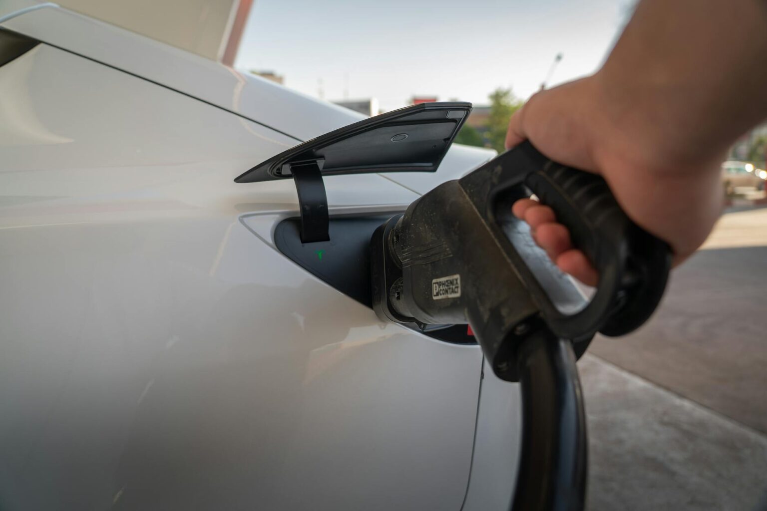 Comparing Tesla Model Y vs Ford Mustang Mach-E Charging Speeds Electric vehicle connected to charging station with charging cable
