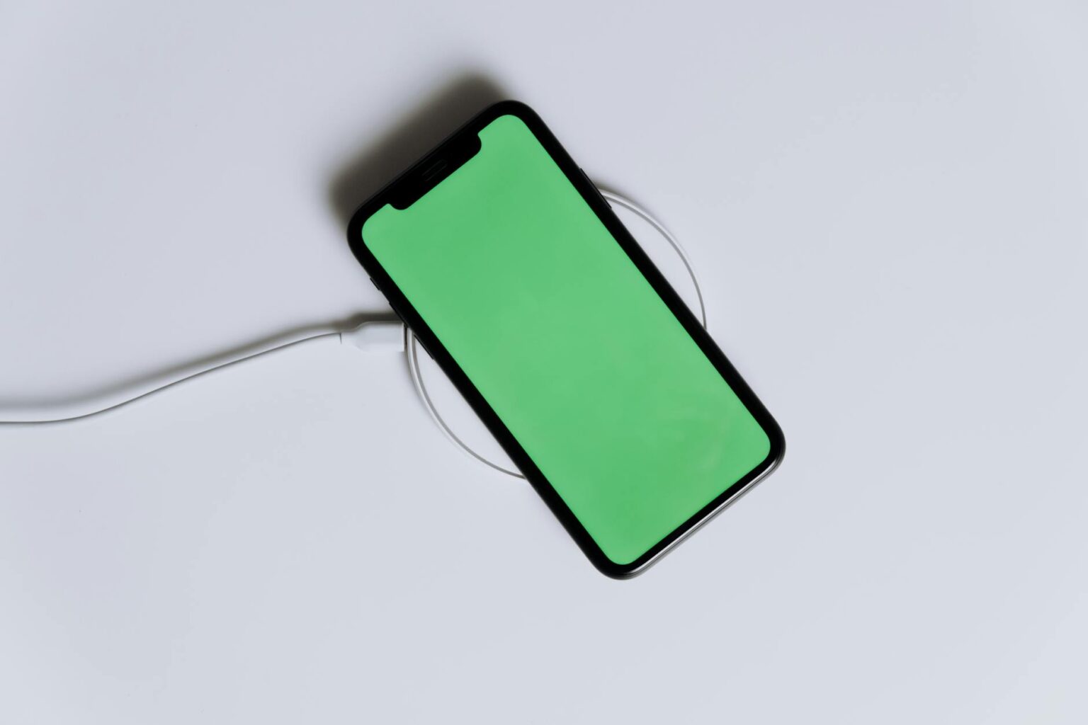 Testing Wireless Charging Pads That Work Through Thick Cases Smartphone positioned on wireless charging pad with thick protective case