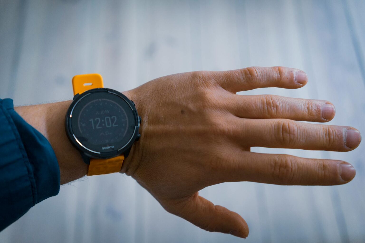 Comparing Apple Watch Ultra 2 vs Garmin Fenix 8 for Hiking Hiker wearing smartwatch while checking trail information on mountain path