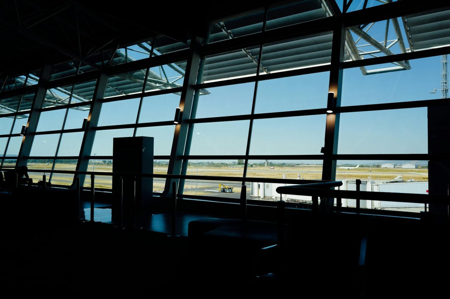 Modern airport terminal with travelers and digital displays showing flight information