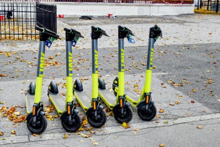 Modern electric scooter parked on urban sidewalk showing sleek design and built-in technology features