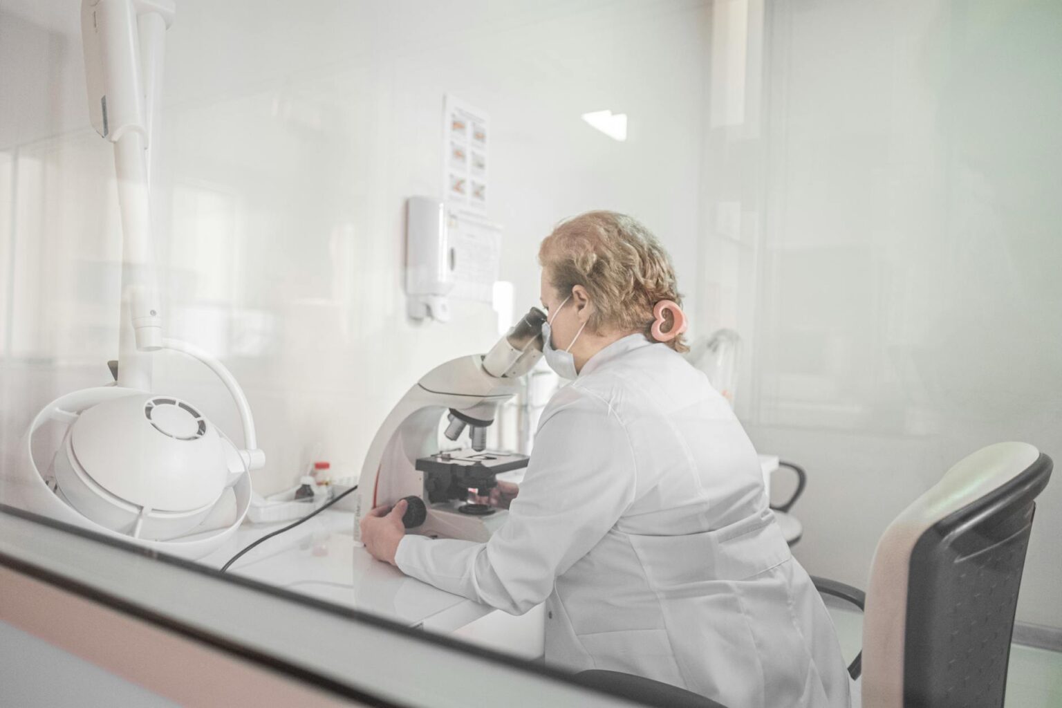Scientist working with advanced laboratory equipment and computer screens showing molecular analysis data