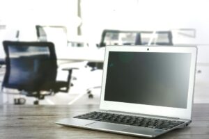 Person working at computer in modern office environment with multiple screens displaying productivity software