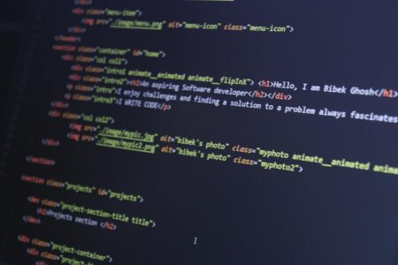 Developer working on computer code with multiple programming windows open on screen