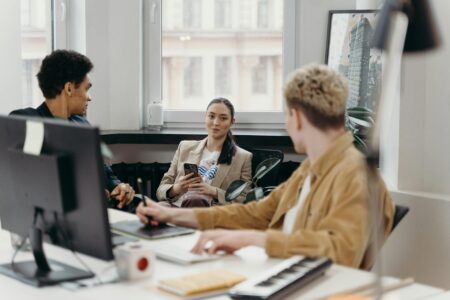 Young professional working at modern office desk with laptop and notebooks