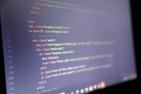 Developer working on code at computer screen showing programming interface