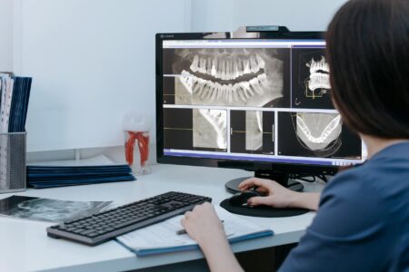 Medical professional analyzing patient data on computer screen with diagnostic imaging