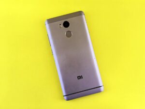 Close-up of finger touching smartphone fingerprint sensor for biometric authentication