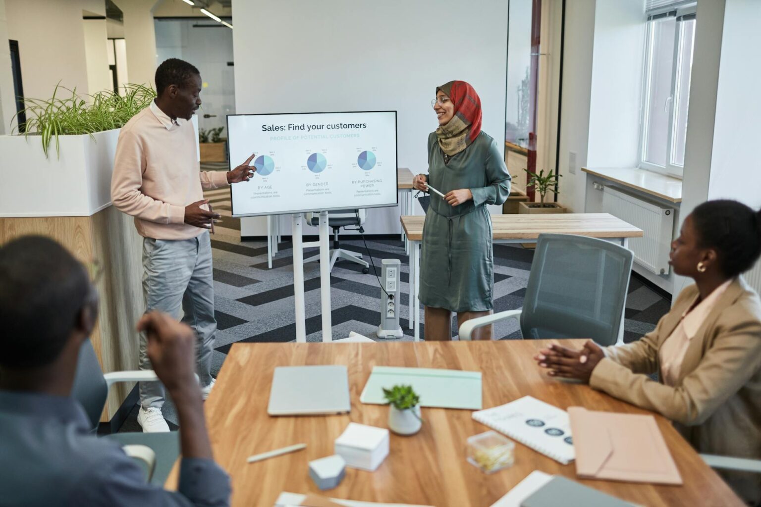 Why Portable Projectors Are Becoming Essential for Remote Presentations Professional presenting to colleagues in modern conference room with projection screen