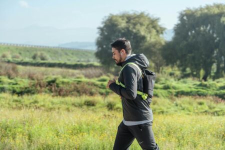 How Bone Conduction Headphones Are Perfect for Outdoor Activities Person wearing headphones while jogging outdoors on a trail