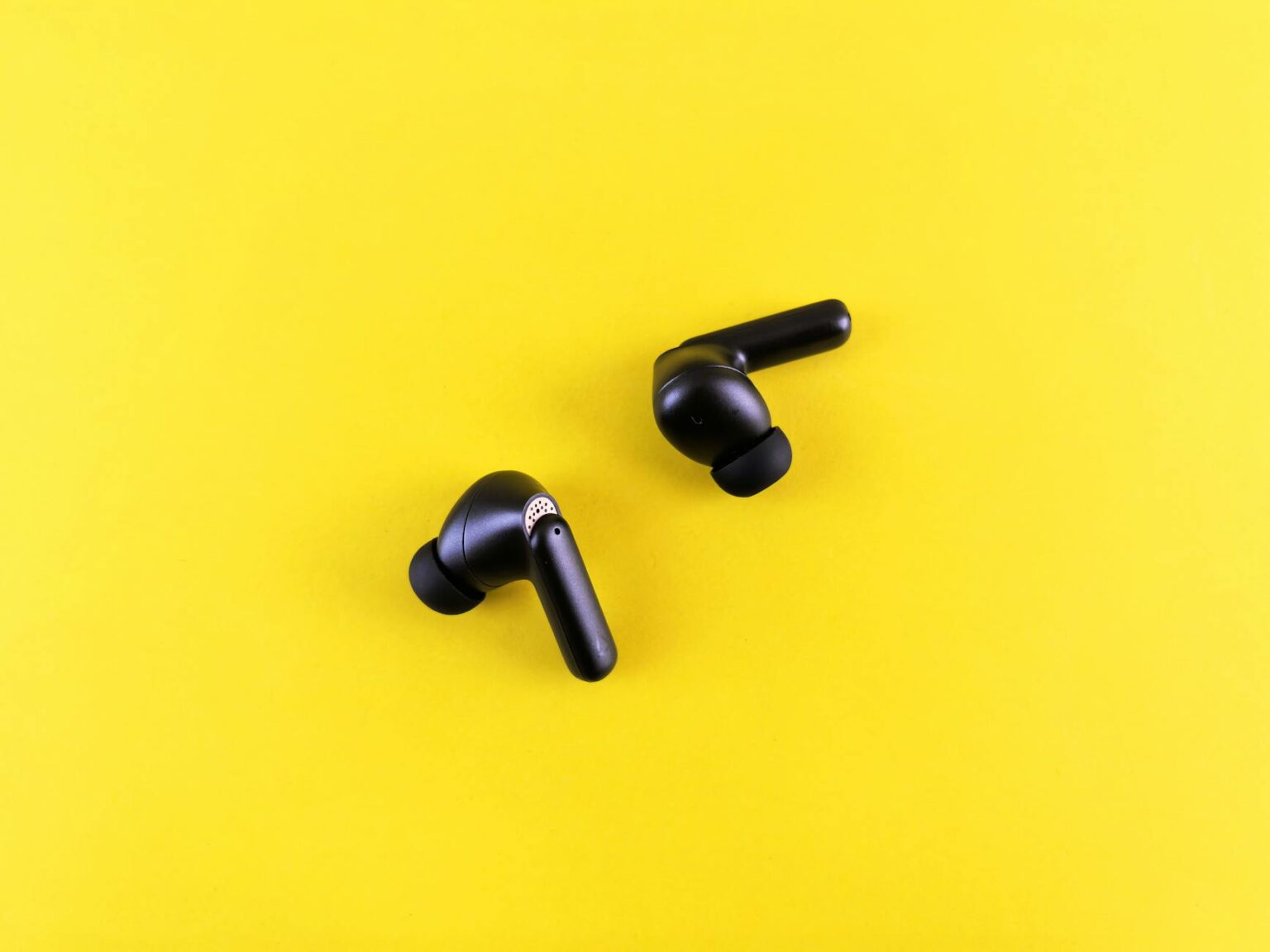 Testing Sony’s New Noise-Canceling Earbuds for Gym Workouts Modern wireless earbuds displayed on clean surface showing sleek design and charging case