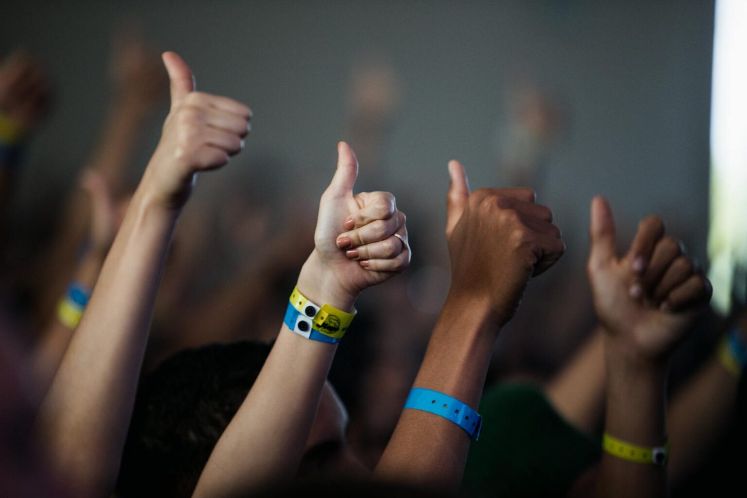 Major Concert Venues Are Installing Biometric Wristbands for Contactless Entry Concert attendees wearing electronic wristbands at a music venue entrance