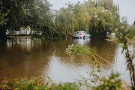 Waymo Robotaxis Get Software Fix for Flood Detection Cars navigating through flooded city street with standing water