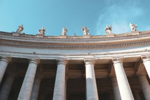 Exterior columns of a grand Vatican-style building representing institutional authority