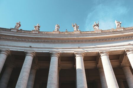 Exterior columns of a grand Vatican-style building representing institutional authority
