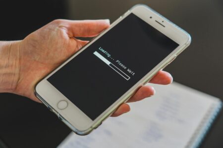 Person holding an iPhone displaying a software update screen
