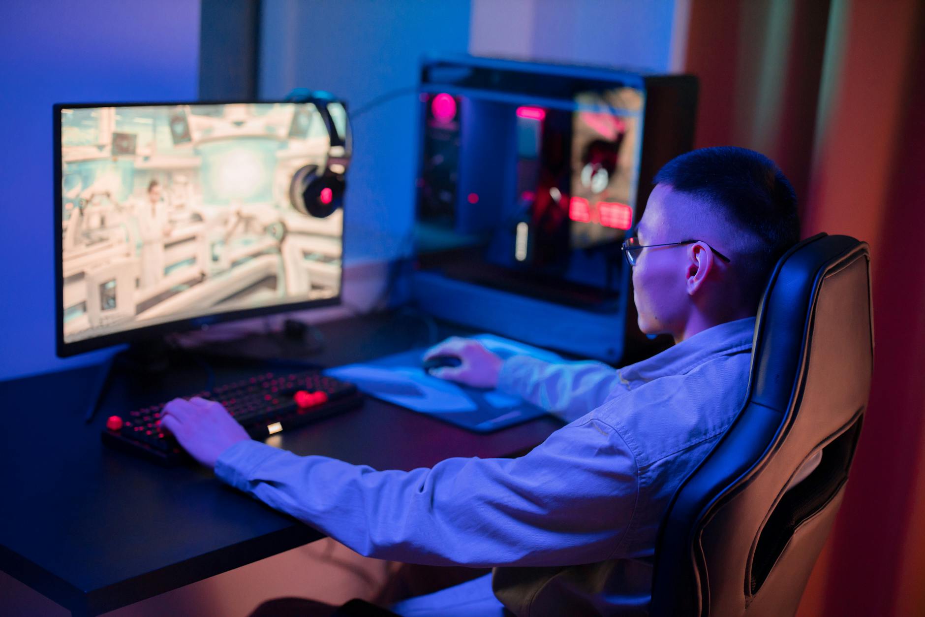 A gaming monitor on a modern desk setup with ambient lighting