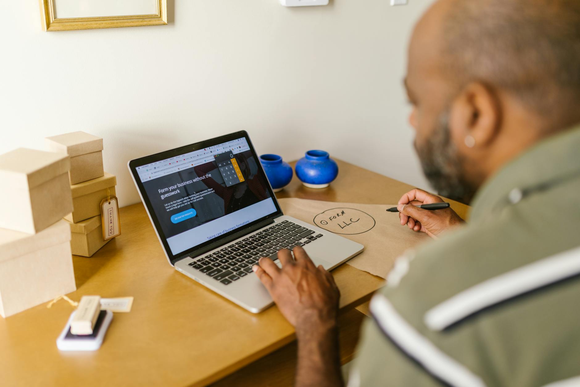 Small business owner working at desk with laptop handling administrative tasks