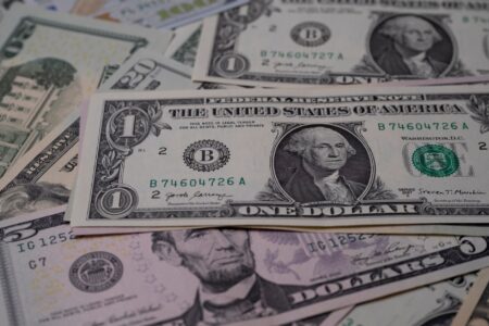 Stack of US dollar bills representing government financial stakes and AI dividend proposals