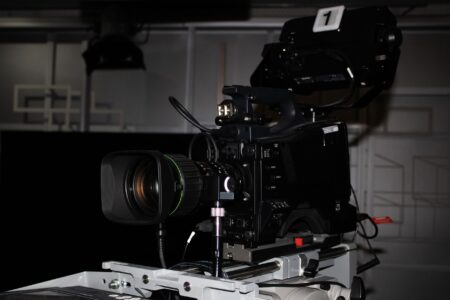 A broadcast television studio with production equipment and screens