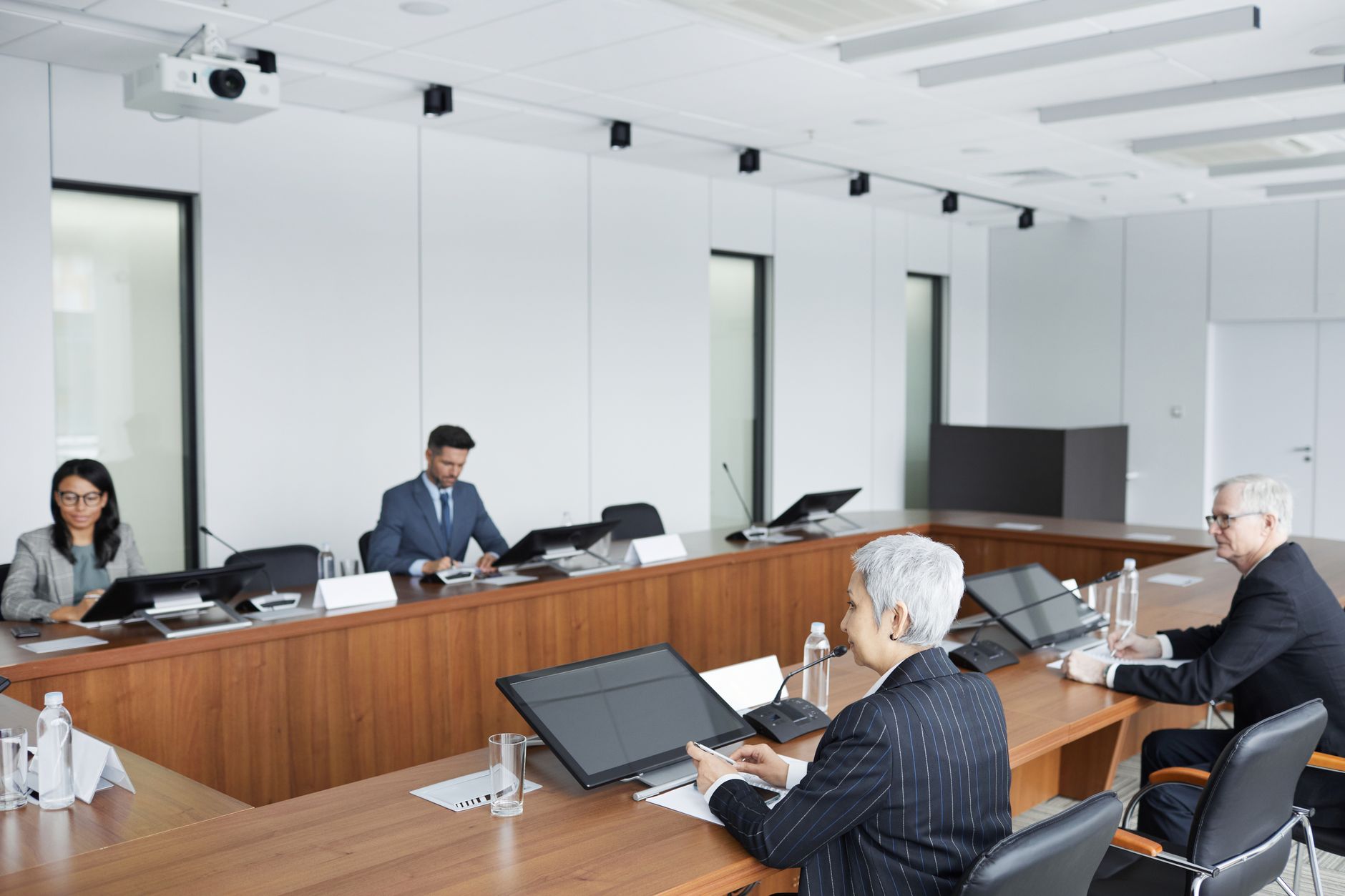 Business executives discussing regulatory policy in a formal boardroom setting