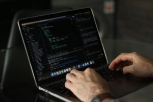 Developer working on a laptop with code on screen