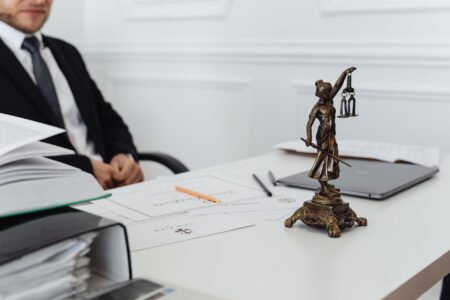 Legal documents on a courtroom table representing a corporate lawsuit settlement