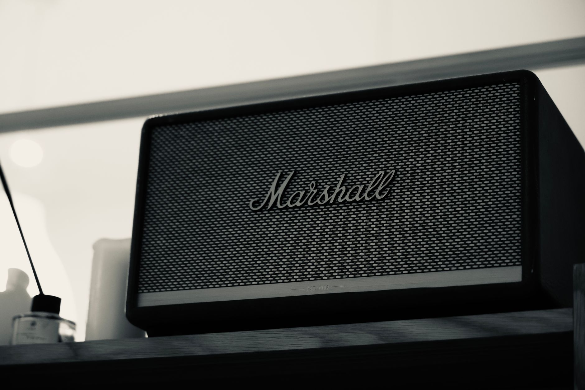 Wireless smart speaker sitting on a shelf in a modern home