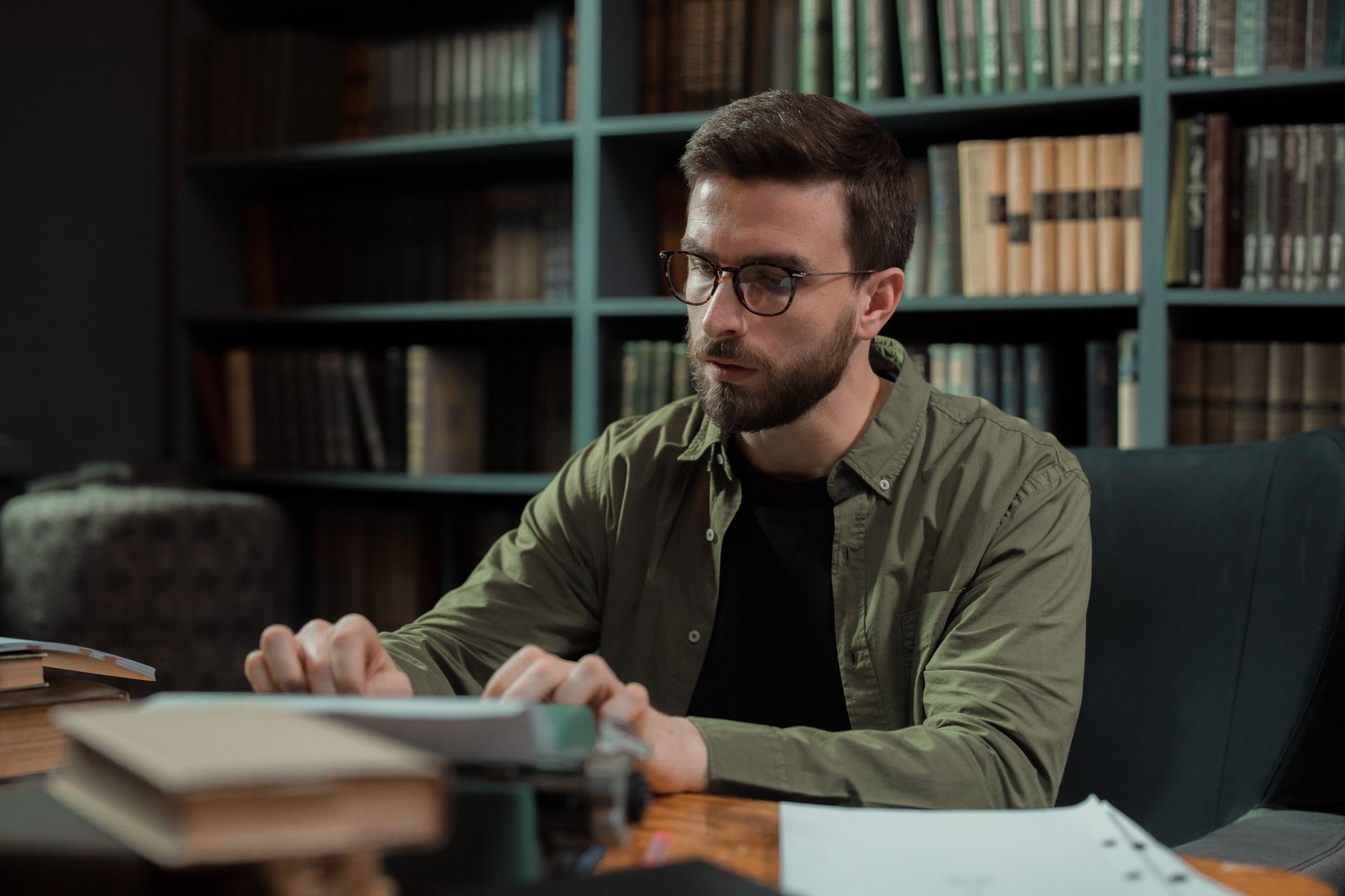 A writer surrounded by stacked books at a desk symbolizing author copyright concerns