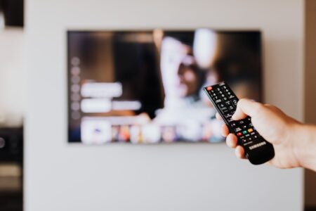 Apple TV+ Quietly Adds 20 Classic Films to Subscriber Library Person browsing a streaming service on a modern television screen