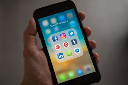 Person holding an iPhone against a neutral background
