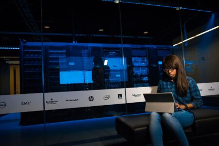 Dark server room with glowing blue lights representing AI infrastructure and autonomous agent activity