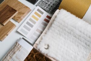 A mood board with home decor swatches and room inspiration photos spread on a table