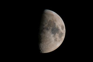 Close-up view of the moon's cratered surface under stark lighting
