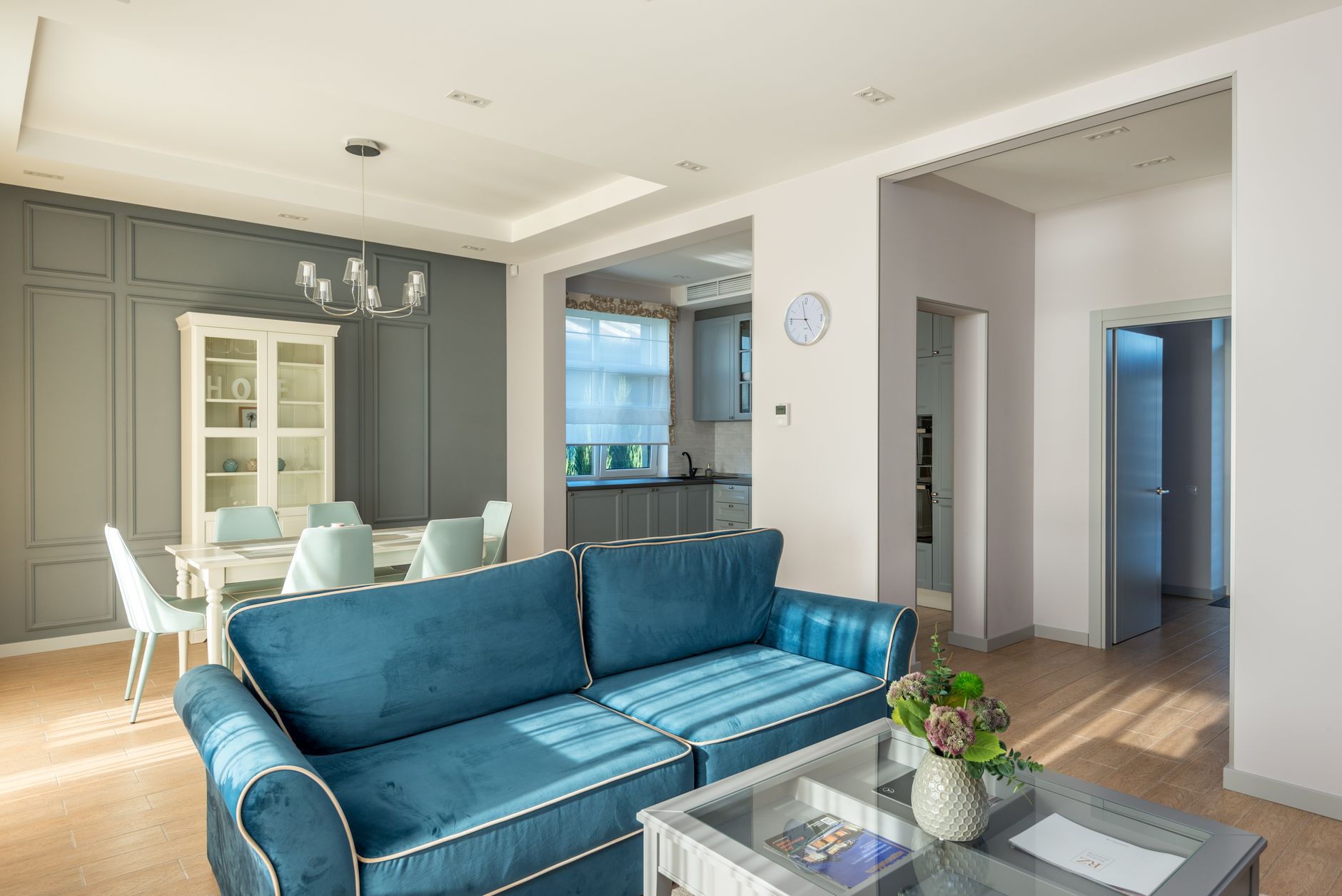 A modern living room with a sofa, coffee table, and pendant lighting