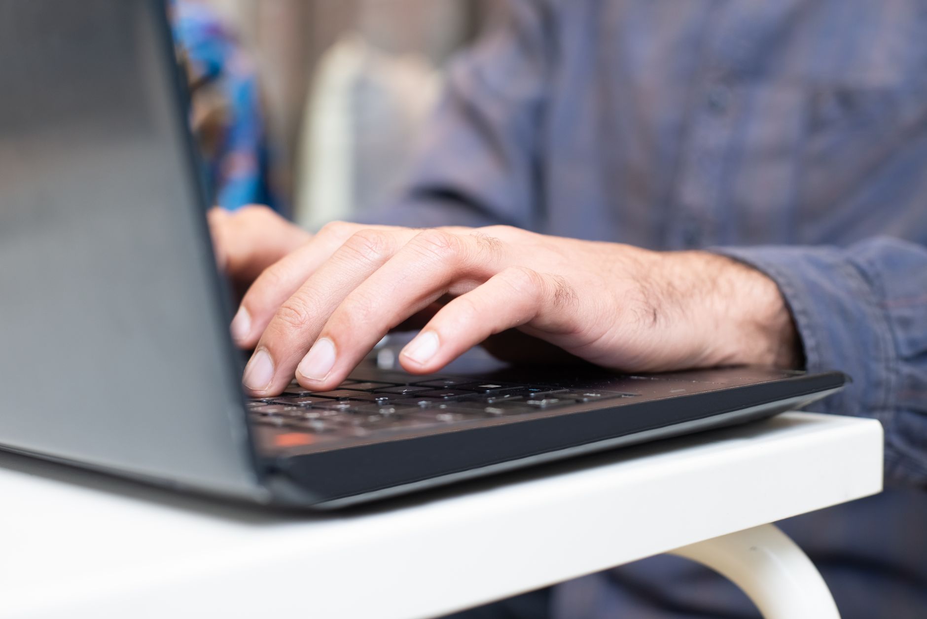 Person working at a laptop in a home or office environment